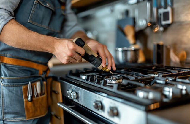 Technician repairing a gas stove burner in a Chandigarh kitchen
