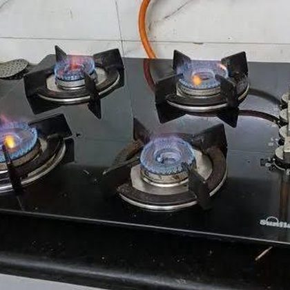 Close-up of a repaired gas stove burner with a stable blue flame